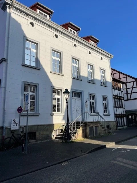 Das Haus in der Jakobistraße 18 in Soest, ein weiß verputztes Altstadtgebäude mit hohen Sprossenfenstern.